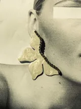 Pendiente en forma de media flor de 7 cm de altura, con detalle en strass y gancho de acero quirúrgico.