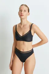 Conjunto de lencería negro, compuesto por un corpiño triangular con breteles regulables y detalles de tul, y una bombacha tiro alto con detalles de tul.