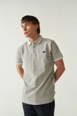 Remera cuello polo gris melange de manga corta, corte regular, con detalles de doble línea blanca en cuello y mangas, logo estampado en el pecho y confección en algodón.