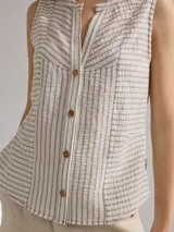 Camisa sin mangas a rayas verticales color beige y blanco, con cuello mao y cierre frontal con botones.