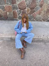 Pantalón de jean celeste de corte acampanado, con costuras verticales en la parte inferior de la pierna y bolsillos delanteros y traseros.
