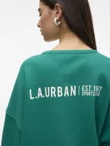 Sudadera verde esmeralda de corte amplio y mangas largas.
