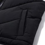Chaleco puffer negro con cuello alto, cierre frontal con cremallera, bolsillos laterales y cordón ajustable en el ruedo.