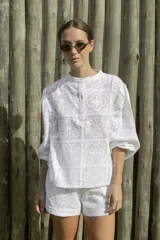 Blusa blanca con diseño calado, cuello mao y mangas 3/4 abullonadas.