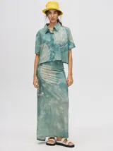 Falda midi marrón con estampado floral en tonos lila, abertura lateral y tiras ajustables.