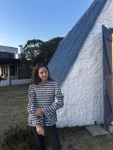 Blusa de manga larga con cuello alto y fruncido en el torso y puños. Estampado a cuadros vichy en tonos marrón y blanco.