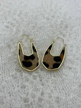 Par de aros colgantes con forma geométrica, con interior de cuero sintético negro con textura de piel de cocodrilo y borde dorado.