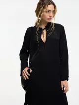 Vestido largo color crema, con cuello mao con lazo ajustable, mangas largas amplias y tajos laterales.
