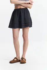 Minifalda negra con cintura elástica y volados en capas.