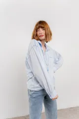Camisa color crema de manga larga con cuello camisero y detalles de encaje en el escote. Se ata en la parte delantera.