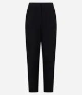 Pantalón de vestir negro, corte carrot (holgado en caderas y ajustado en tobillos), con talle alto, pliegues frontales y cierre tradicional con botón forrado.