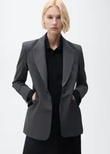 Chaqueta gris con estampado de micro pata de gallo, cuello con solapa, cierre de botón frontal, dos bolsillos delanteros con ribete y solapa, manga larga abotonada y forro interior.