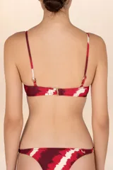 Top de bikini con estampado abstracto en tonos rojo, borgoña y blanco. Tiene tirantes finos y copas con fruncido central.
