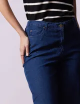 Jean elastizado de corte recto, color azul denim, con pretina con pasadores, botón y cierre. Tiene tres bolsillos delanteros y dos bolsillos traseros.