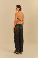 Pantalón negro de corte amplio y fluido, con detalle de encaje floral.