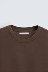 Camiseta marrón de punto, corte regular, cuello redondo y manga corta con terminaciones en rib.