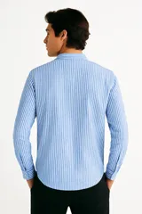 Camisa de manga larga a rayas verticales color beige y blanco, con cuello clásico, cierre con botones y bolsillo de parche en el pecho. Corte recto.