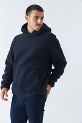 Canguro de sherpa polar azul marino con capucha, bolsillo tipo canguro y logo de goma en el pecho.