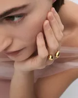 Anillo dorado con dos esferas irregulares.