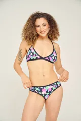 Conjunto de bikini con corpiño triangular con tirantes finos y bombacha clásica, ambos con estampado animal print multicolor y ribetes negros.