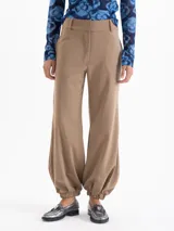 Pantalón Victoria gris confeccionado en lanilla con fit amplio y cómodo. Cuenta con bolsillos ocultos en el delantero y bolsillos ojal en la parte trasera. Presenta presillas y ajuste en los tobillos mediante elástico, que aporta una silueta relajada y caída.