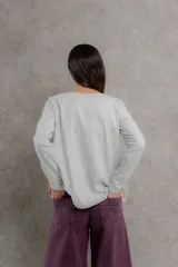 Remera negra de manga larga con costuras decorativas en color ocre en hombros y escote.