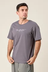 Remera blanca de algodón con estampado frontal que incluye el texto "The Boston Est. 1997" y un texto vertical más largo en el lateral.