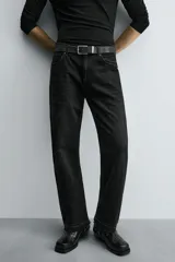 Pantalón de jean celeste de corte flare, con tiro medio, cinco bolsillos, cierre frontal con cremallera y botón, y bajo con acabado irregular.