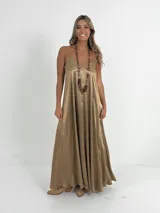 Vestido italiano amplio con escote en V, confeccionado en tela nacarada con cuerpo que aporta estructura y movimiento.