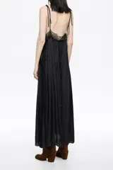 Vestido largo de corte línea A, confeccionado en tejido plisado con estampado de piel de serpiente en tonos marrón, negro y celeste. Presenta escote en pico pronunciado con tirantes de lazo ajustables y detalles de encaje negro en el escote y a lo largo del frente y laterales.