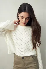 Sweater negro calado con diseño de líneas diagonales en relieve y mangas acampanadas.