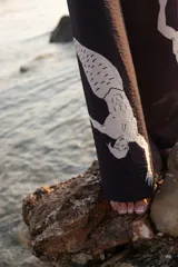 Pantalón palazzo negro con cintura elástica y estampado de sirenas blancas.