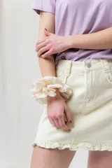 Minifalda de denim color crema con volados en los bolsillos delanteros y en el ruedo.