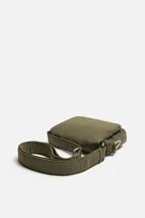 Bandolera negra de nylon con solapa y cierre magnético. Tiene correa ajustable con mosquetón y bolsillo interior.
