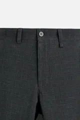 Pantalón slim fit negro confeccionado en tejido con elasticidad en ambas direcciones. Cuenta con bolsillos frontales y traseros de vivo con botón. Cierre frontal con cremallera y botón.