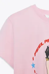 Camiseta rosa de manga corta y cuello redondo con estampado de Betty Boop y texto "I feel pretty in red". Debido al proceso de tintado y lavado, el color de cada prenda es único y especial por lo que puede presentar diferencias con respecto al mostrado en la foto.