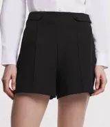 Shorts negros de sastrería con detalle de botones en los laterales y pliegues.