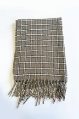 Bufanda rectangular color gris con estampado a cuadros blancos y negros. Incluye flecos en los extremos.