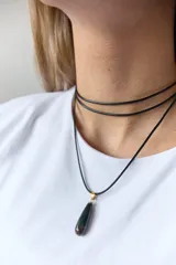 Gargantilla con tira de cuero negro y dije de piedra natural azul en forma de gota.