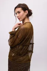 Camisa de chiffon negra con brillos plateados, escote en V, mangas largas abullonadas y jaretas para fruncir y entallar.