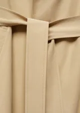 Abrigo color verde oliva, largo hasta la rodilla, con cuello de solapa, manga larga con trabillas, dos bolsillos laterales, abertura posterior en el bajo y cinturón desmontable.