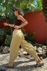 Pantalón largo de tela liviana con estampado vichy en tonos amarillo y blanco, corte amplio y cintura elastizada.