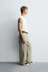 Pantalón de jean blanco, corte holgado y amplio en toda la pierna, tiro medio, tejido ligero, cinco bolsillos, efecto lavado y cierre frontal con cremallera y botón.