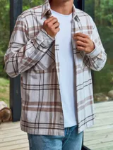 Sobrecamisa a cuadros color crema, marrón y blanco, de manga larga con cierre de botones y bolsillos en el pecho.