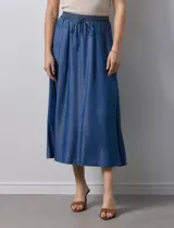 Falda larga de lyocell color celeste, marca Cyrus. Tiene pretina ancha elastizada con lazo ajustable y bolsillos laterales en la costura.