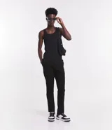 Pantalón de sarga negro, corte skinny, con cierre de botón y cremallera, bolsillos laterales y traseros, y trabillas en la cintura.