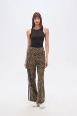 Pantalón ancho de tiro medio con estampado animal print de leopardo en tonos marrones y negros. Presenta una franja lateral deportiva en blanco y negro.