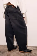 Pantalón de jean negro de corte amplio, con tiro medio y ruedo con dobladillo.