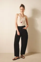 Pantalón jean negro de tiro medio y calce holgado, confeccionado en denim rígido con lavado suavizado.