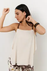 Musculosa blanca de lino con breteles finos con cuentas de madera.